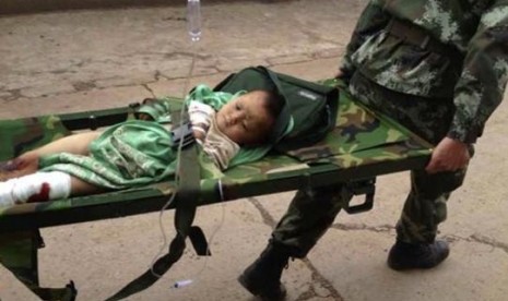 An injured child is carried by paramilitary policemen on a stretcher after an earthquake hit Longtoushan township of Ludian county, Yunnan province August 3, 2014.