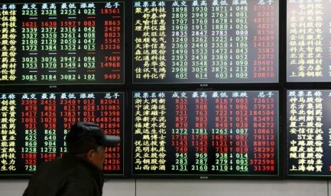  An investor looks at information displayed on an electronic screen at a brokerage house in Shanghai, December 8, 2014. 