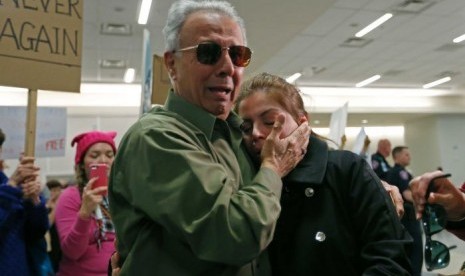 An Iranian green card holder cries on the shoulders of her father after being released, January 28, 2017.