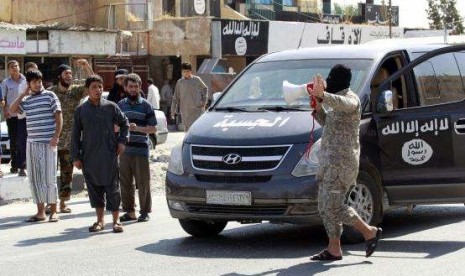 An Islamic State militant uses a loud-hailer to announce to residents of Tabqa city that Tabqa air base has fallen to Islamic State militants, in nearby Raqqa city August 24, 2014.