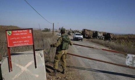 An Israel soldier opens gate as a UN convoy carrying Fijian UN peacekeepers released by al-Qaeda-linked group Nusra Front in Syria on Thursday, drives towards Golan heights on September 11, 2014.