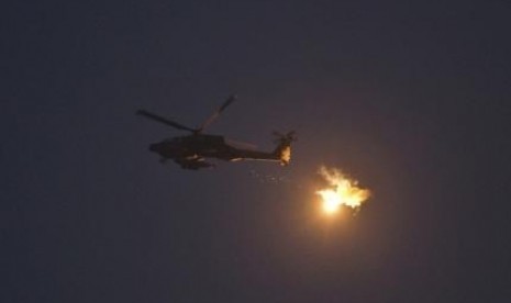 An Israeli Apache helicopter fires flares above Israel near the border with the northern Gaza Strip July 22, 2014.   