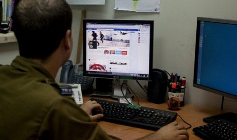 An Israeli soldier looks at the Facebook page of the Israel Defense Force, at the IDF spokesperson's office in Jerusalem on November 15. In a media bunker, attached to Israel’s press office, hundreds of volunteers work around the clock on every major socia