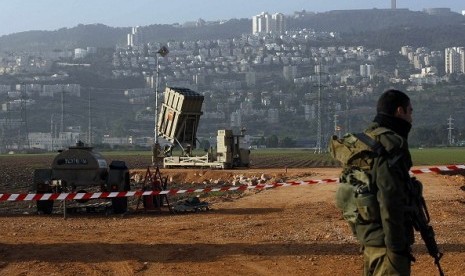 An Israeli soldier stands guard next to an Iron Dome rocket interceptor battery deployed near the northern Israeli city of Haifa. (File photo)