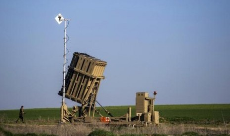 An Israeli soldier walks near the launcher of an Iron Dome missile interceptor battery deployed in Ashkelon January 16, 2014.