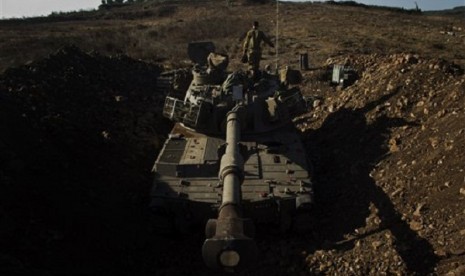 An Israeli soldier walks over a mobile artillery unit in the Golan Heights, near the border between the Israeli-controlled Golan Heights and Syria, Sunday, Sept. 1, 2013. 