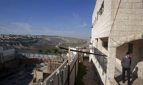 An Israeli walks near a construction site in the east Jerusalem neighborhood of Ramat Sholmo, Tuesday, Dec. 18, 2012. An European diplomat says Germany and three other European members of the UN Security Council are preparing a statement condemning Israel's plan to accelerate settlement building.