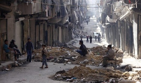 An old man (right) sits on a chair on a street after inspecting his house damaged by what activists say was shelling by forces loyal to Syria's President Bashar al-Assad in Aleppo's Bustan al-Basha district on November 29, 2012. (file photo)  