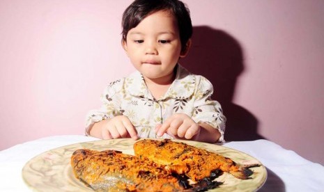 Anak makan ikan (ilustrasi). Alergi seafood termasuk alergi yang bisa bertahan hingga dewasa.