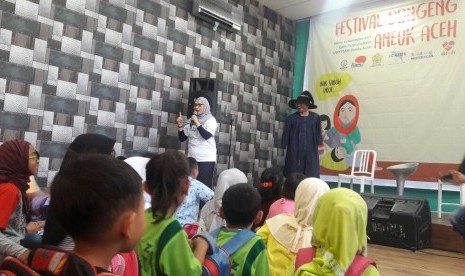 Anak-anak Aceh sedang mendengarkan dongeng yang dibawakan oleh Pendongeng dari Komunitas Ayo Dongeng Indonesia dalam rangka Roadshow Festival Dongeng Internasional Indonesia (FDII).