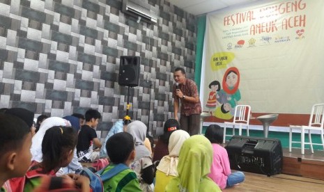 Anak-anak Aceh sedang mendengarkan dongeng yang dibawakan oleh Pendongeng dari Komunitas Ayo Dongeng Indonesia dalam rangka Roadshow Festival Dongeng Internasional Indonesia (FDII).