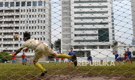 Anak-anak berebut bola saat pertandingan perempat final sepak bola berlatar belakang rusunawa.