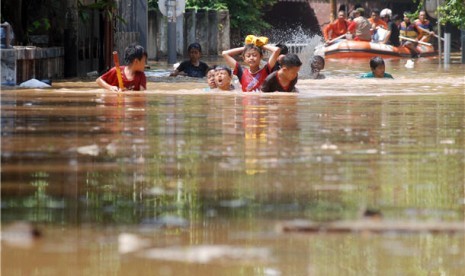 Anak-anak berjalan melawan genangan banjir yang melanda Jakarta. (ilustrasi) 