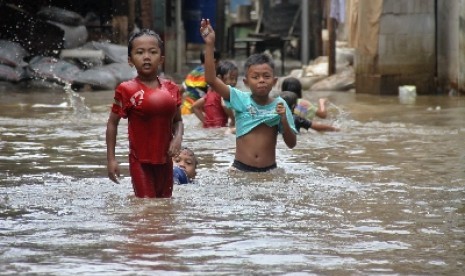 Anak-anak bermain air saat banjir melanda perkampungan di Petogogan, Jakarta Selatan