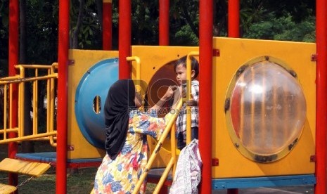 Anak-anak bermain ayunan di Taman Menteng Jakarta, Kamis (10/12).