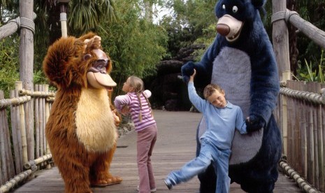 Anak-anak bermain dengan tokoh karakter di Disneyland Paris.