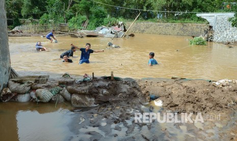 Anak-anak bermain di area tanggul jebol 