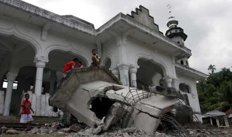  Anak-anak bermain di kubah masjid yang rusak akibat gempa di desa Pulo Kawa, Kecamatan Tangse, Kabupaten Pidie, Selasa (22/1). 