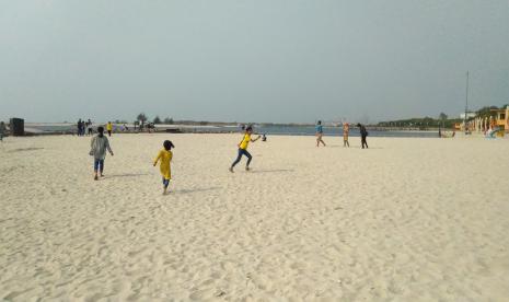 Anak-anak bermain di Pantai Ancol, Jakarta Utara