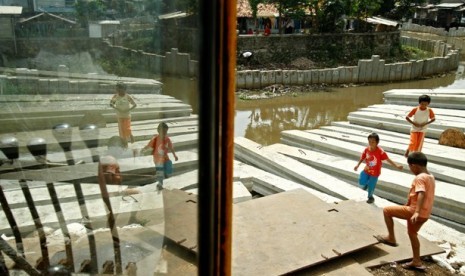 Anak-anak bermain di sekitar proyek normalisasi dan pengerukan sungai di Kali Ciliwung Lama, Kramat Dalam, Jakarta Pusat.