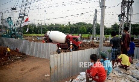 Anak-anak bermain di sekitar proyek pembangunan rel kereta api bandara di Kawasan Manggarai, Jakarta, Kamis (27/4).