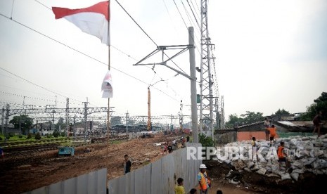 Anak-anak bermain di sekitar proyek pembangunan rel kereta api bandara di Kawasan Manggarai, Jakarta, Kamis (27/4).