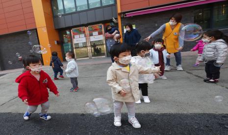 Anak-anak bermasker tengah bermain balon di Kuil Chogyesa di Korea Selatan.