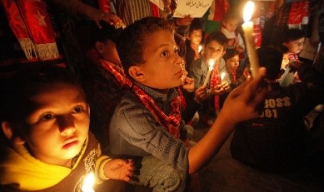 Anak-anak di Jalur Gaza, Palestina, menyalakan lilin.