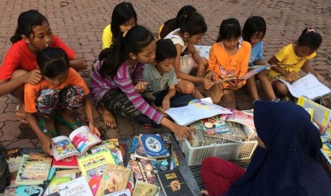 Anak-anak di Lapangan Atletik Cepu, Blora, Jawa Tengah, antusias meminjam dan membaca buku.