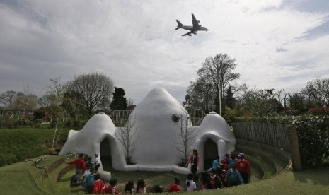 Anak-anak di sekolah pendidikan dini Hounslow Heath di London mengelilingi salah satu dari empat bangunan berkubah di sekolah mereka yang dibangun untuk meredam suara pesawat.