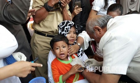 Anak-anak di Surabaya menjalani pemberian imunisasi Measles Rubella (MR) di Lapangan Putro Agung Kelurahan Karah, Surabaya, Selasa (1/8). 