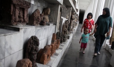 Anak-anak didampingi orang tuanya melihat sejarah relief dan patung di Museum Nasional Indonesia, Jakarta Pusat, Ahad (9/2).