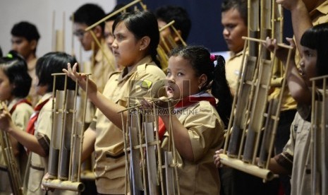 Ilustrasi anak-anak memainkan alat musik tradisional angklung.