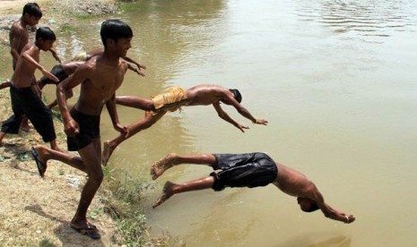 Anak-anak India bermain air di tengah gelombang panas.