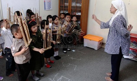 Anak-anak kelas B PAUD Mekar Gondangdia belajar bermain alat musik angklung, Jakarta Pusat, Kamis (20/2). 