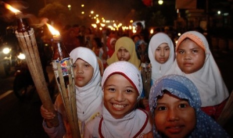 Anak-anak melakukan pawai obor saat malam takbir di Jalan Matraman, Jakarta Timur,Ahad (27/7). Pawai tersebut dalam rangka menyambut Hari Raya Idul Fitri 1 Syawal 1435 H dan tabuh beduk dan menyalakan kembang api sebagai hari kemenangan bagi umat Islam. 