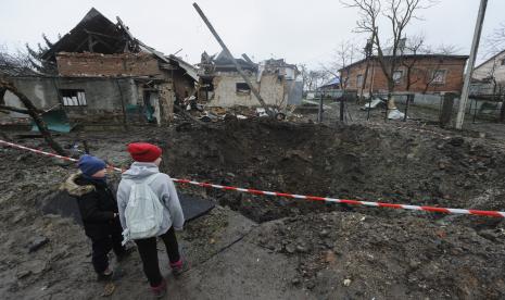 Anak-anak melihat kawah yang tercipta akibat ledakan di daerah pemukiman setelah penembakan Rusia di Solonka, wilayah Lviv, Ukraina pada 16 November 2022. Pengadilan pidana internasional di Den Haag Pengadilan Kejahatan Internasional (ICC) telah mendakwa Presiden Rusia Vladimir Putin dan Komisaris Badan Anak-Anak Rusia Maria Lvova-Belova atas penculikan massal anak-anak Ukraina. Surat perintah penangkapan untuk mereka pun telah rilis.