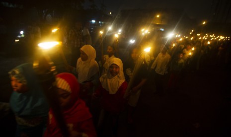 Anak-anak mengikuti pawai obor pada malam takbiran di kawasan Matraman, Jakarta, Ahad (27/7). 