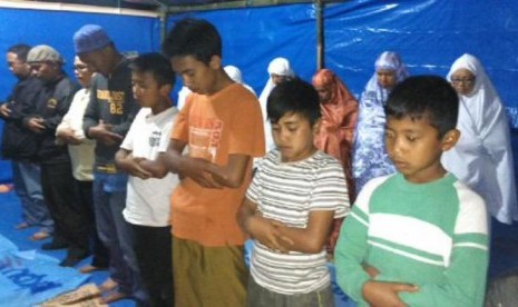 anak-anak pengungsi erupsi sinabung sedang melaksanakan shalat berjamaah