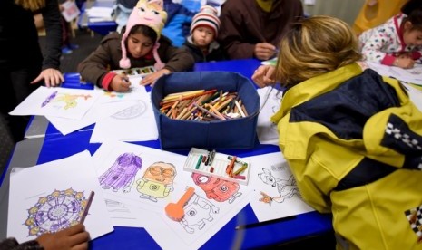 Anak-anak pengungsi imigran mewarnai di kamp pengungsian Celle, Jerman.