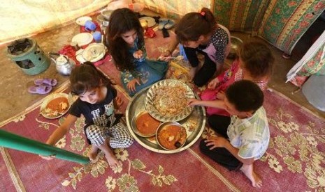 Anak-anak pengungsi sedang makan di sebuah tenda di luar Fallujah, Irak, Senin, 14 Juni 2016. Pengungsi di Fallujah kekurangan makanan selama Ramadhan. 