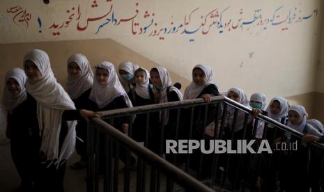 Anak-anak perempuan berjalan ke atas saat mereka memasuki sekolah sebelum kelas di Kabul, Afghanistan, Ahad (12/9).