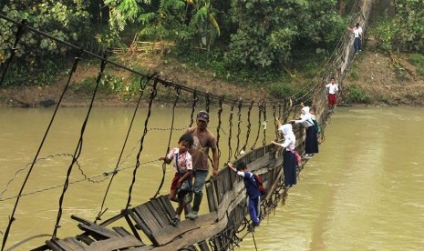 Anak-anak sekolah di Lebak, Banten, meniti jembatan yang rusak yang sangat berbahaya untuk menuju ke sekolah.