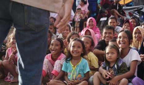 Anak-anak yang berada di Posko Posko Pengungsian Dusun Wombo Kalonggo, Tanantovea, Donggala, Sulawesi Tengah, dihibur oleh pendongeng dari Gerakan Para Pendongeng untuk Kemanusiaan (Geppuk), Mujani (29), Jumat (12/10).