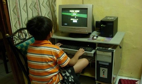 Anak Laki laki yang sedang Main Game di Komputer (ilustrasi).