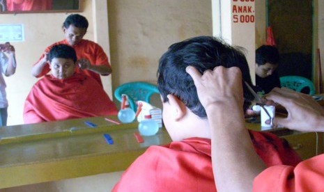 anak laki laki yang sedang potong rambut di Pangkas rambut  (ilustrasi).