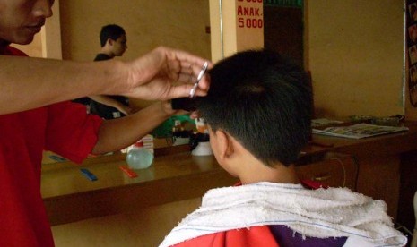 anak laki laki yang sedang potong rambut di Pangkas rambut  (ilustrasi).