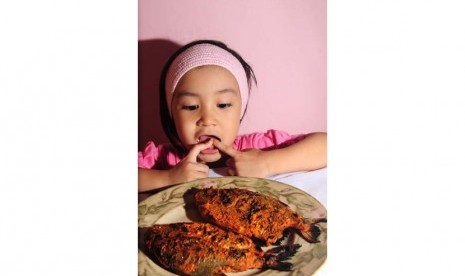 Anak makan ikan (ilustrasi).