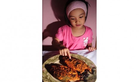 Anak makan ikan (ilustrasi).