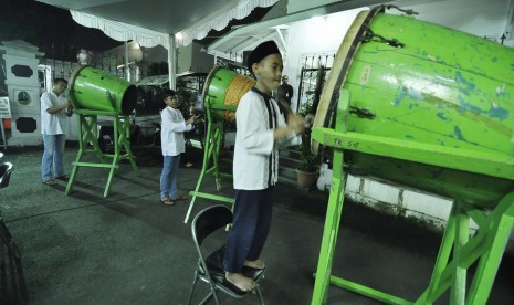 Anak menabuh beduk di malam takbiran.